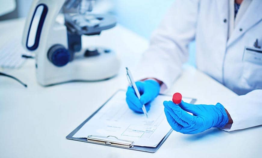 Nurse labeling vials of blood after lab draw.