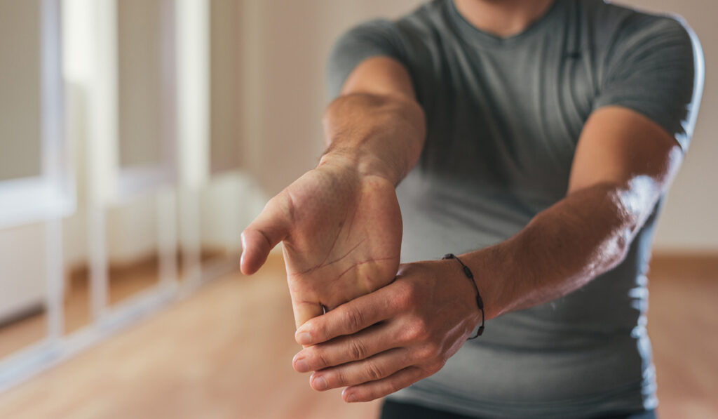 Man is performing his daily stretching routine to help prevent injury.