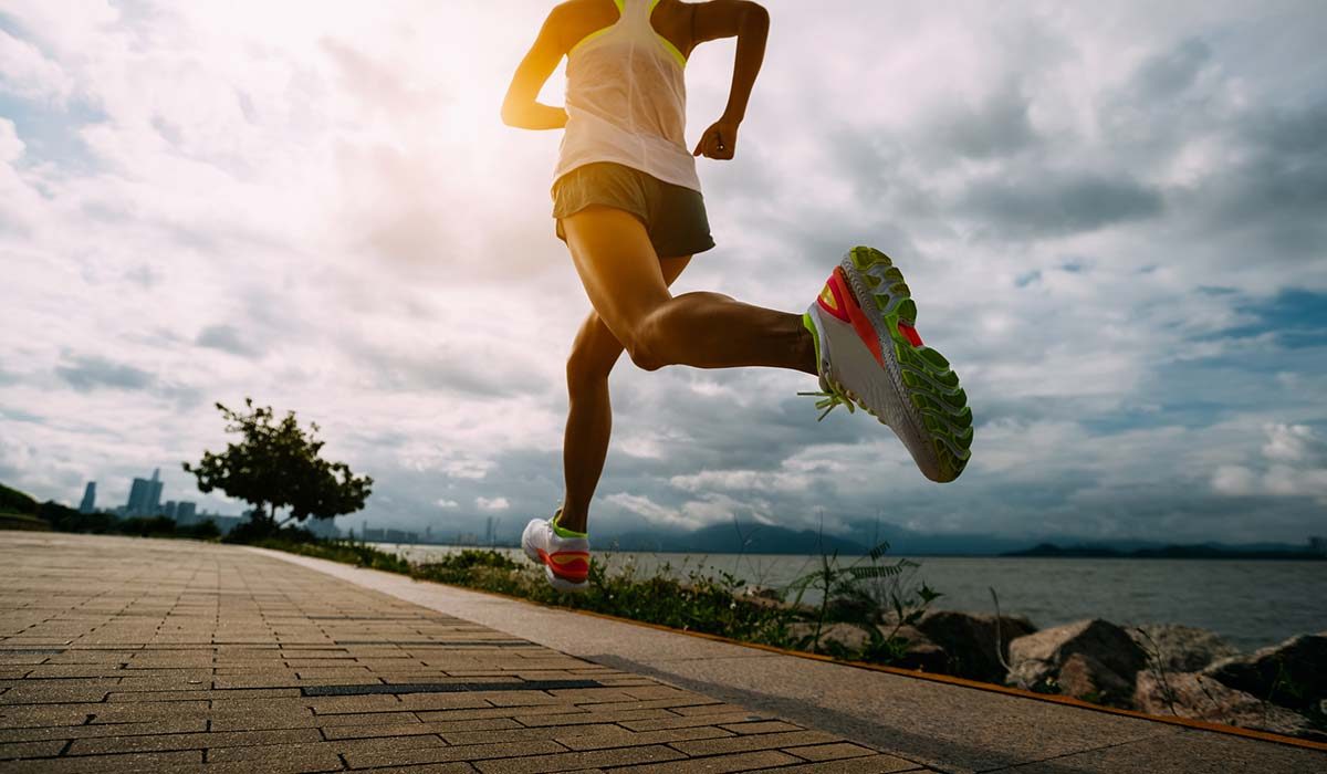 A well-hydrated person running alongside a lake.